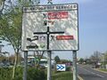 A roundabout sign showing McDonald's and Scott's Fish & Chips.